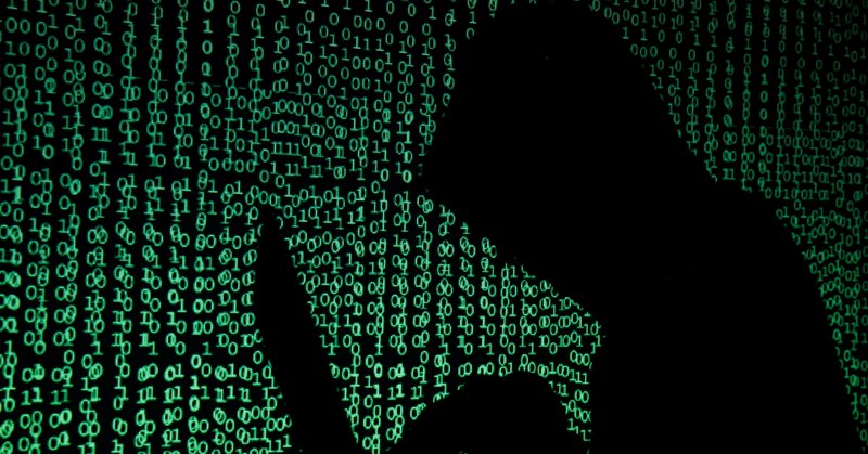 A hooded man holds a laptop computer as cyber code is projected on him in this illustration picture taken on May 13, 2017. REUTERS/Kacper Pempel/Illustration