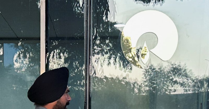 A guard walks past the Reliance Industries logo near the entrance of Dhirubhai Ambani Knowledge City in Navi Mumbai, March 15, 2024. REUTERS/Francis Mascarenhas