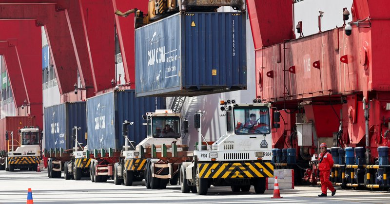 Container transporter trucks line up to be unloaded by gantry cranes at Yangshan Port outside of Shanghai, China, June 17, 2025. REUTERS/Go Nakamura
