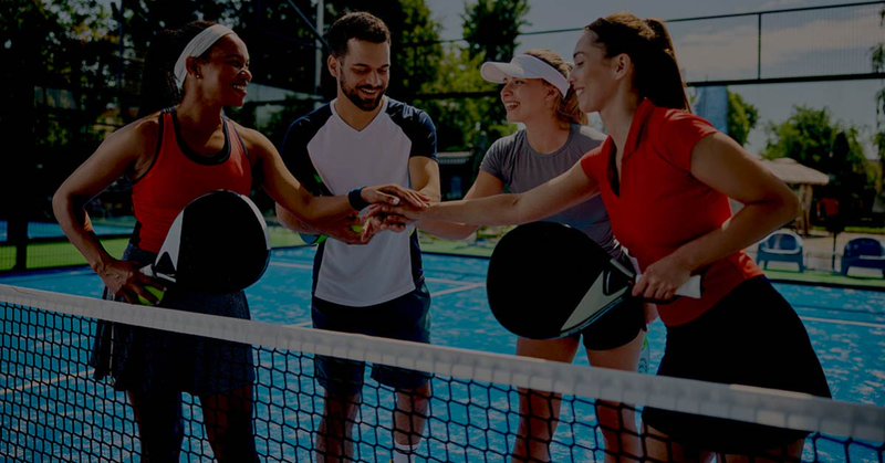 Paddle tennis players celebrating teamwork and unity—symbolizing strong financial collaboration with Ramp and Gravity Software