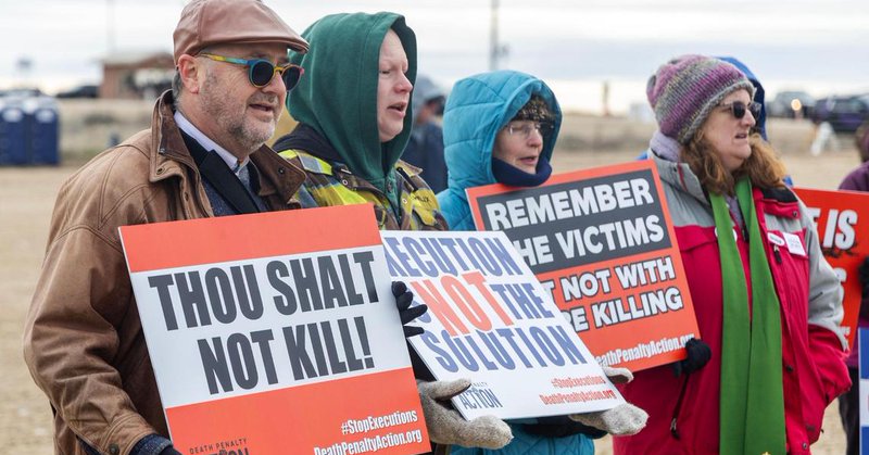 The Rev. Duane Anders of the Cathedral of the Rockies, left, and the Rev. Buddy Gharring of Hillview United Methodist Church, second from left, sing “Amazing Grace” with other protesters against the death penalty on Wednesday outside of the Idaho Maximum Security Institution in Kuna.