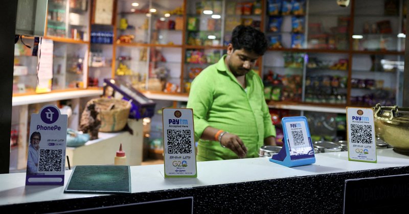 QR codes of digital payment firms PhonePe and Paytm are seen on the counter of a grocery store in Ahmedabad, India, February 5, 2024. REUTERS/Amit Dave/File Photo