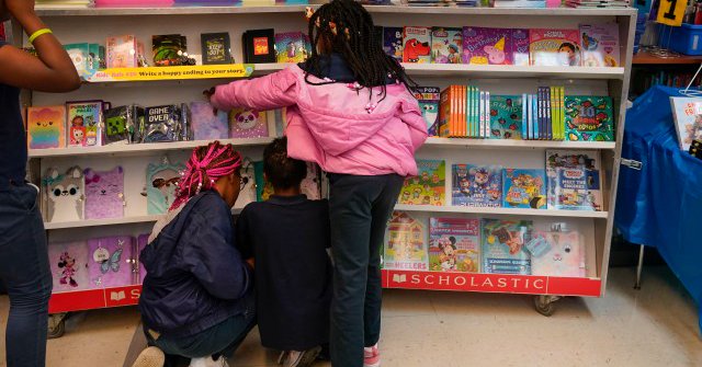 Students look at books during a book fair at Schaumburg Elementary, part of the ReNEW charter network, in New Orleans on April 19, 2023. Mississippi, Alabama and Louisiana have seen a promising turnaround in their student reading scores after passing a series of similar literacy reforms. (Gerald Herbert/AP)
