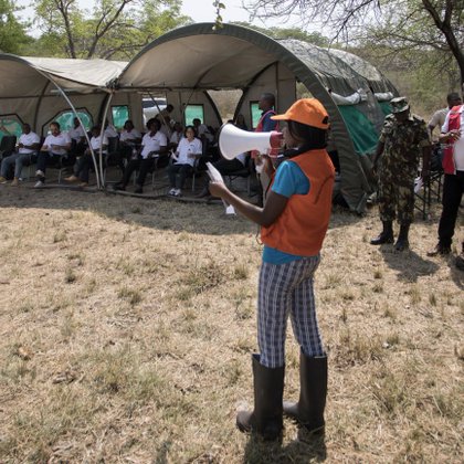 A group of people standing in front of tents.