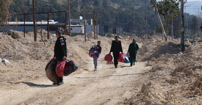 Los miembros de una familia palestina llevan sus pertenencias en el campo de refugiados de Nur Shams, en el norte de Cisjordania.