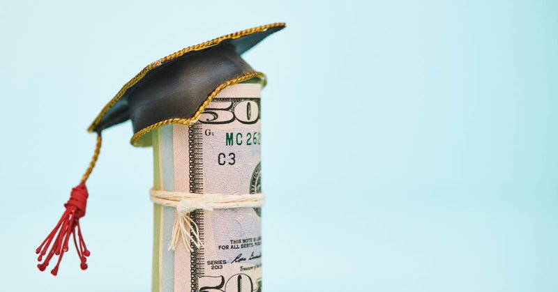 Money roll in graduation cap, stock photo | Getty Images