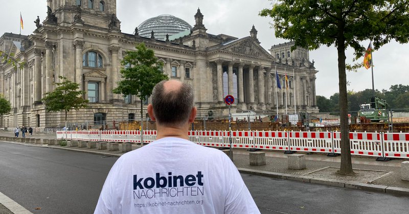 Person mit kobinet-T-Shirt mit Blick auf den Reichstag