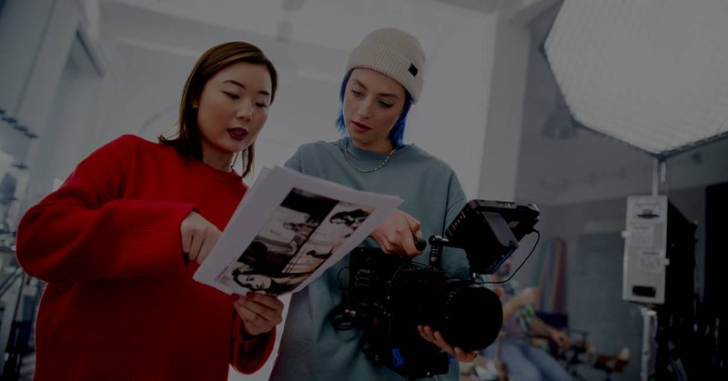 Two women in the film industry reviewing scenes together, discussing key financial decisions and accounting strategies for entertainment companies in a creative environment.