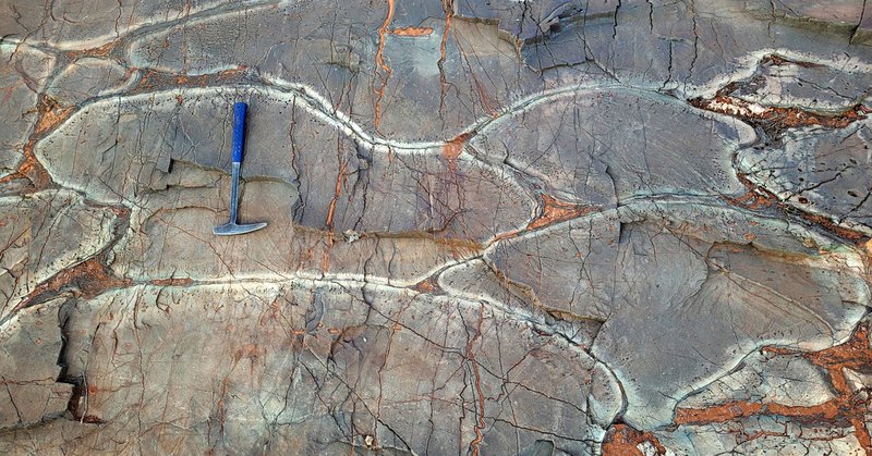 Wavy, blobby form of rock with cracks across it