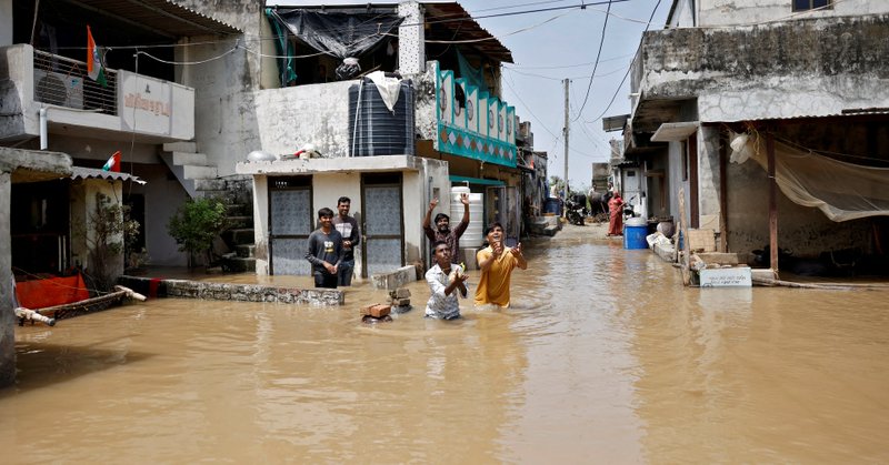 Residents in a flood-affected neighbourhood receive food packets that are being distributed by government officials following heavy rain in Kheda district of the western state of Gujarat, India, September 8, 2025. REUTERS/Amit Dave/File Photo
