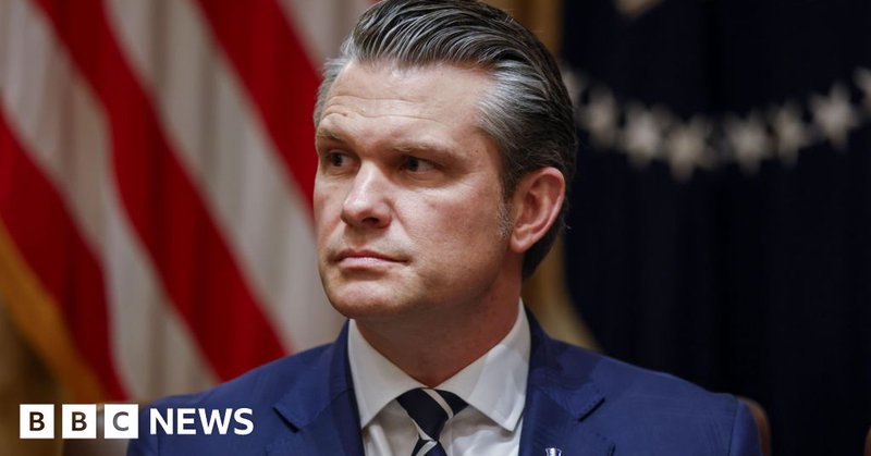 Pete Hegseth, wearing a blue suit, blue and white striped neck tie and a lapel pin, during a meeting at the White House.