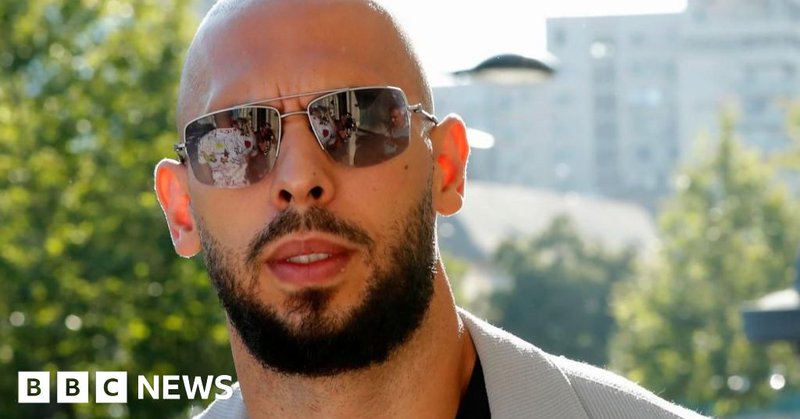 A shot of Andrew Tate from the shoulders up showing him outside wearing a pair of sunglasses.