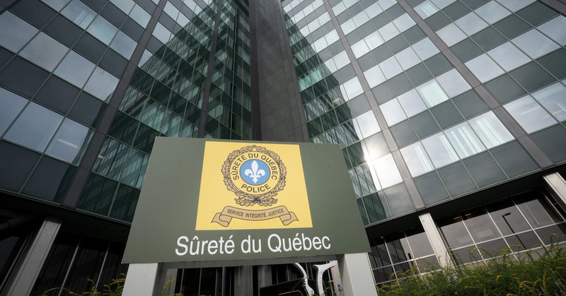 Le logo de la SQ devant un édifice.