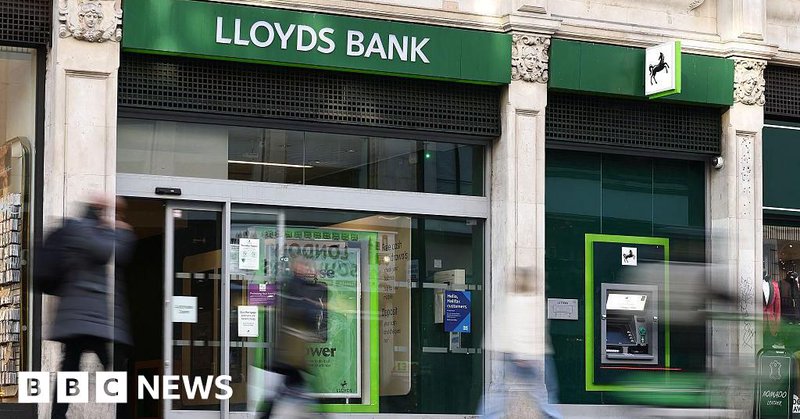 People walk past a Lloyds Bank branch on a UK high street.
