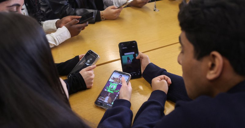 Students from Ricards Lodge and Rutlish High Schools in Wimbledon look at their mobile phones during an interview and discussion with Reuters about their thoughts on a social media ban for under 16s, in London, Britain, February 23, 2026, REUTERS/Katie Collins