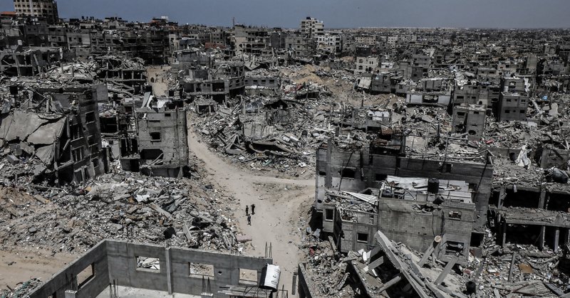 People walk past destroyed buildings in Khan Younis in the southern Gaza Strip on April 21, 2024 (Photo: Omar Ashtawy / APA Images)