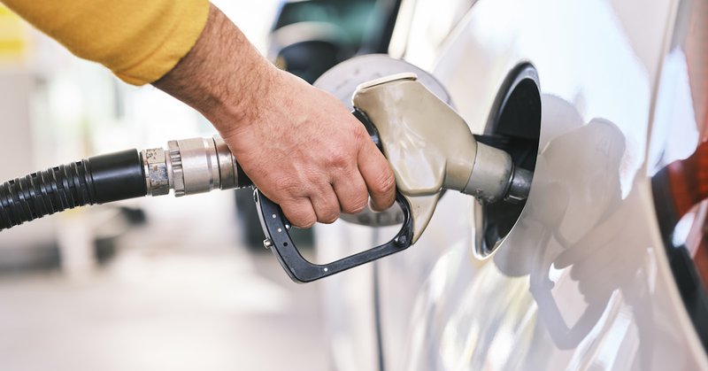 a man pumping gas into his car at a gas station