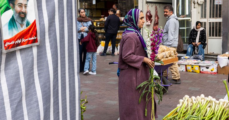 A woman carries flowers at a market as people prepare for Nowruz celebrations, on March 19, 2026, in Tehran, Iran.