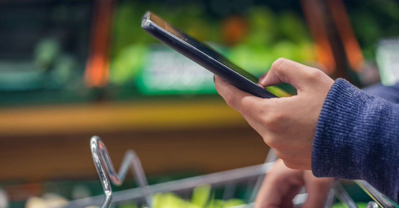 Hand holding a phone in grocery store