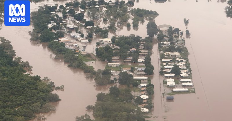 Brown water spills across streets in a small community, shown from above.
