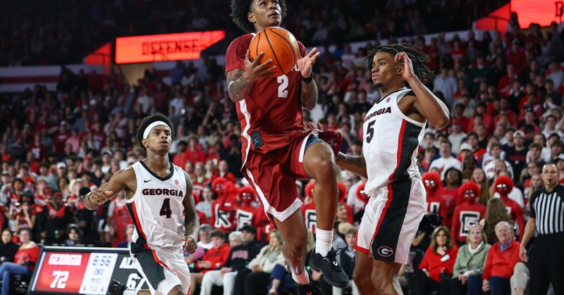 Alabama guard Aden Holloway (2) shoots against Georgia guards Marcus Millender (4) and Jeremiah Wilkinson (5) during the second half of an NCAA college basketball game, Tuesday, March 3, 2026, in Athens, Ga. (AP Photo/Colin Hubbard)
