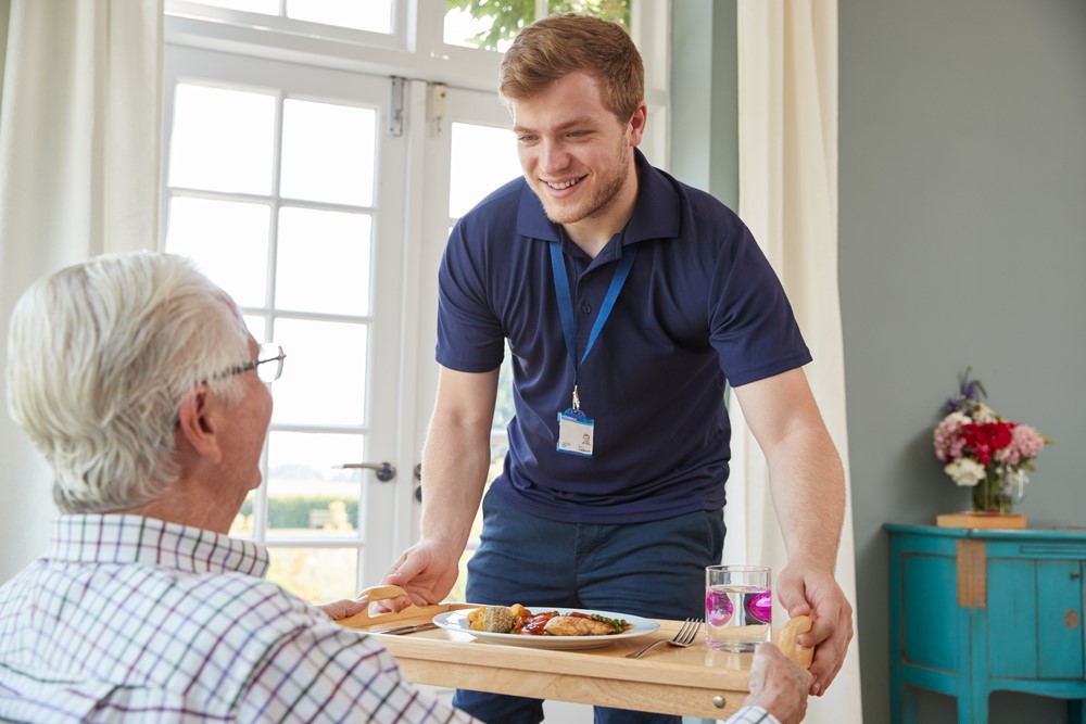 Care worker serving a meal