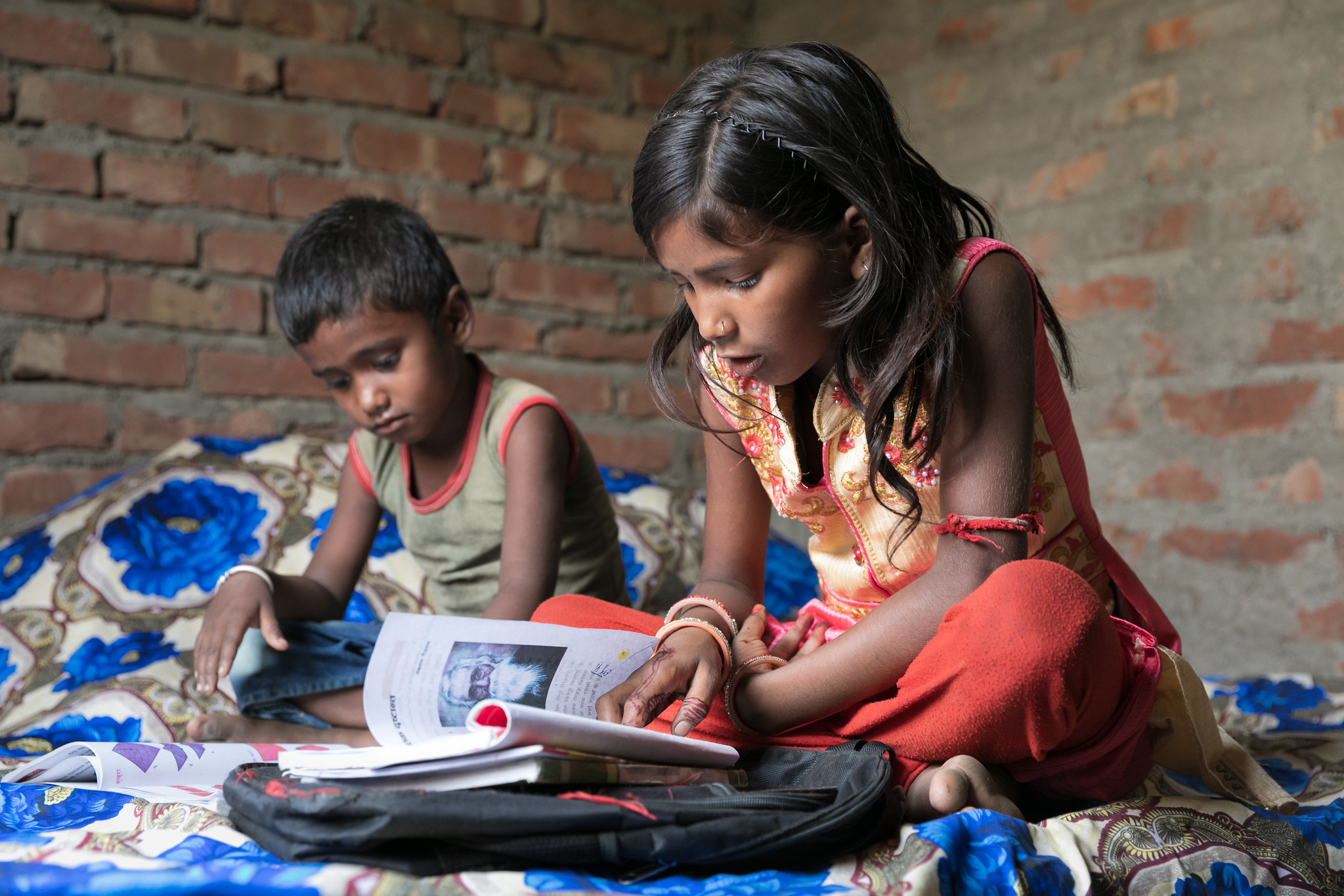 Barsha Kumari Pashawal, 12, does her homework accompanied by her younger brother Badal, 5.     Two years ago Barsha, like many Dalit girls in her community, was not in school. She spent her days helping her mother at home, watching the goats, helping to take care of her two younger siblings while her mother went to the market or to cut firewood, and doing household chores. Nepal, June 2019. Credit: GPE / Kelley Lynch