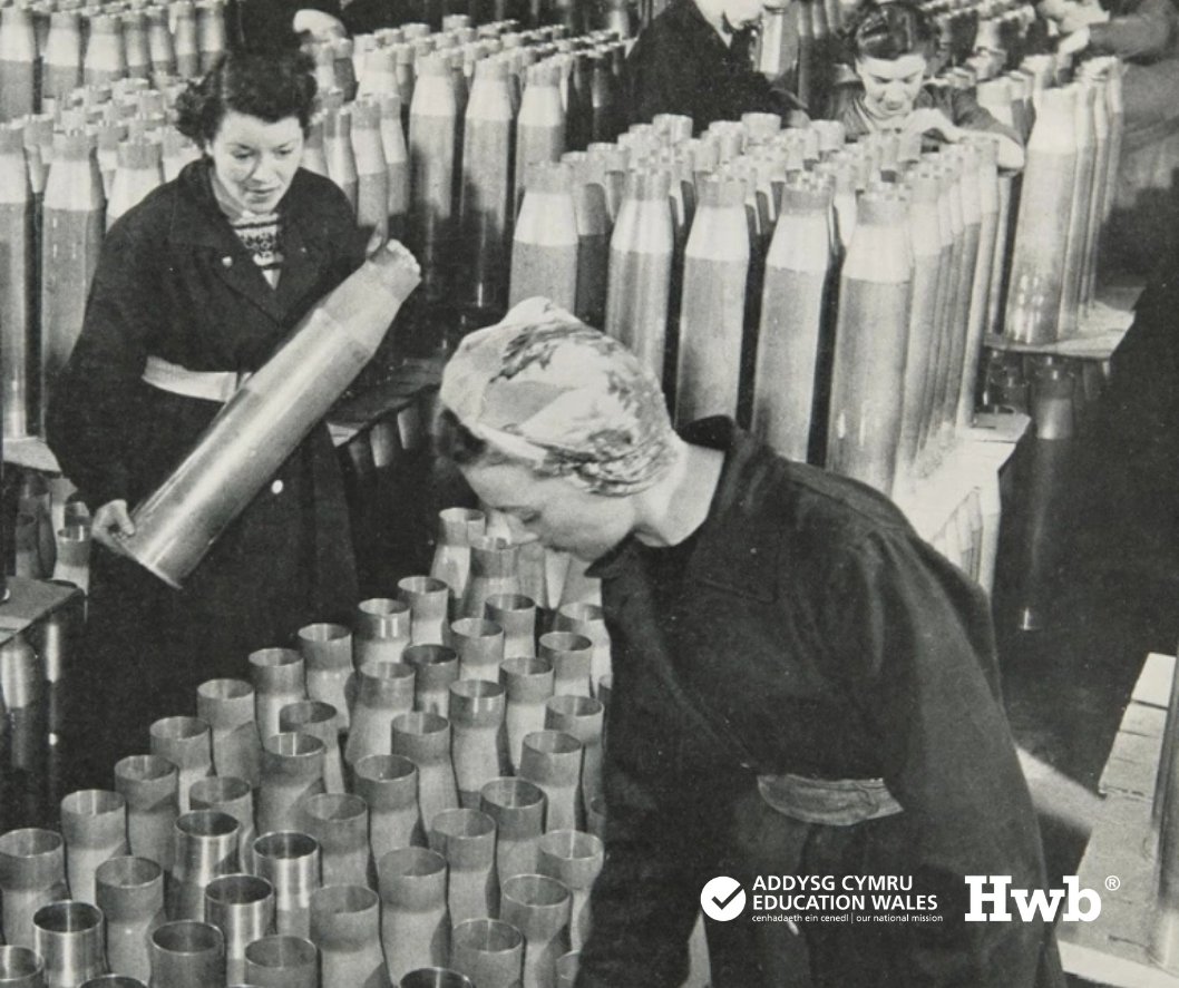 Menywod yn archwilio ac yn cydosod cregyn magnelau mawr mewn lleoliad ffatri yn ystod y rhyfel.