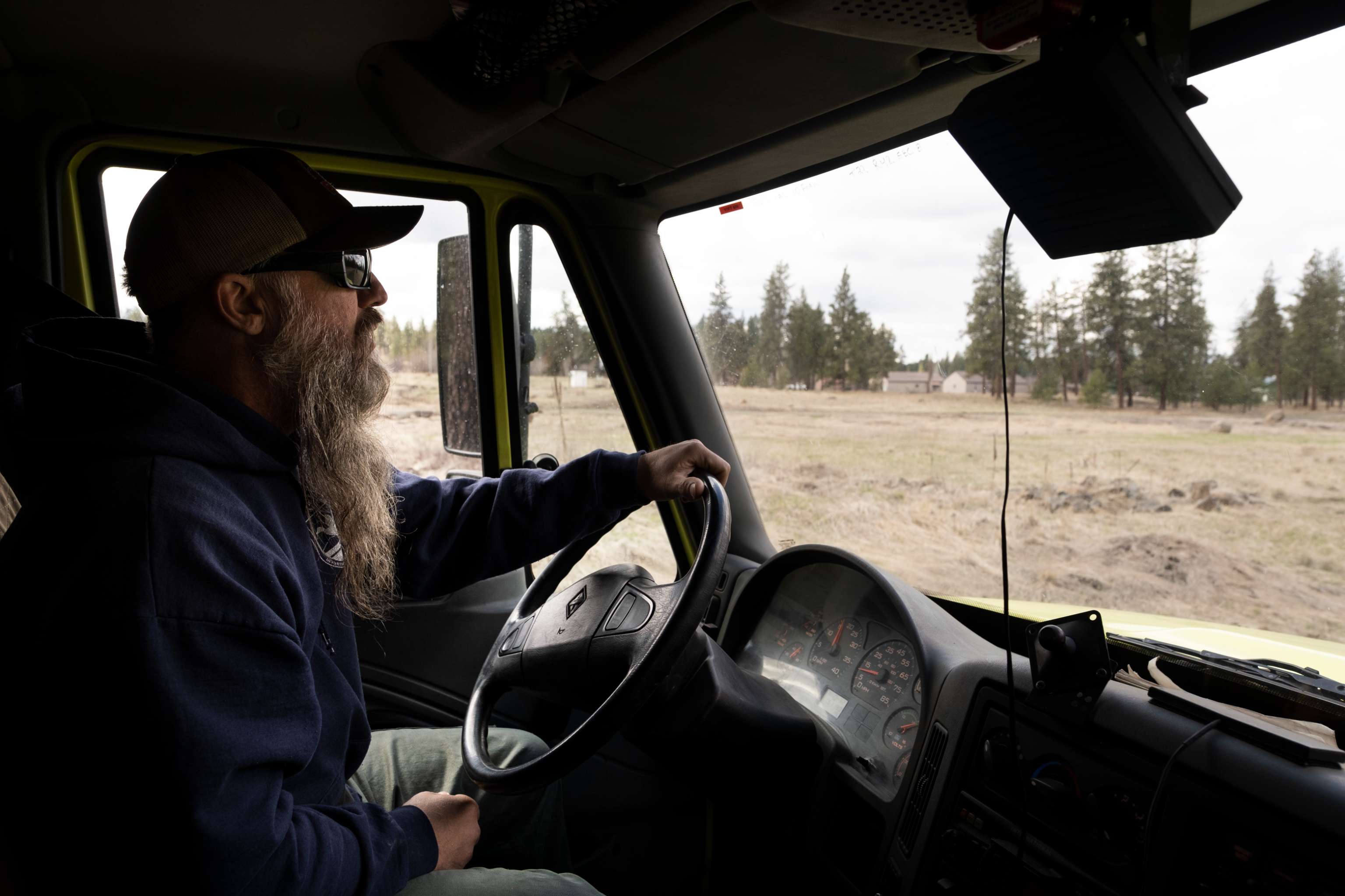 A firefighter drives an engine. The view is from inside the cab.
