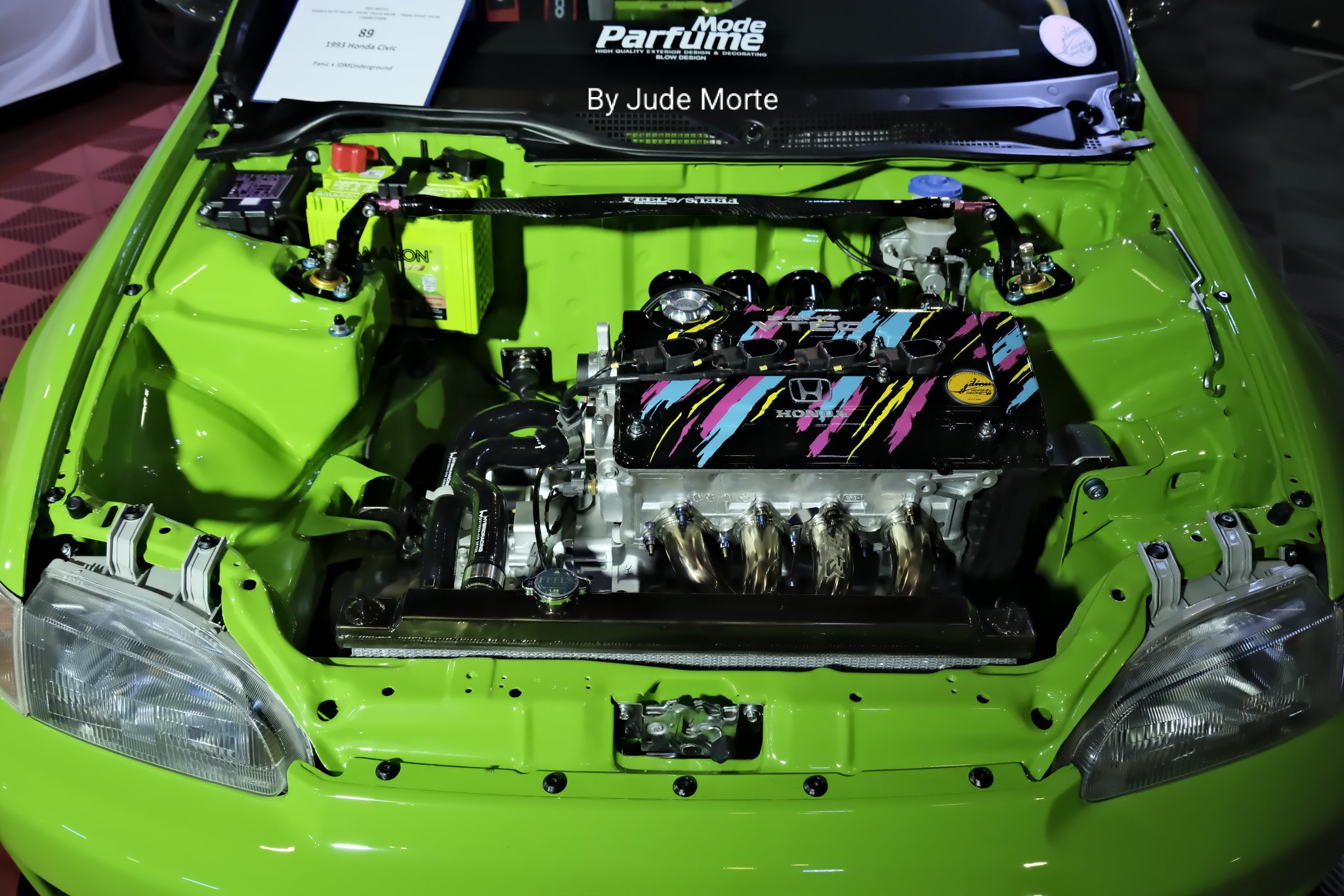 Green 1991-1995 Honda Civic hatchback engine bay (with the engine proper sporting a black valve cover with pink/blue/yellow stripes, gold headers and polished powerplant block) on display at the 13-16 November 2025 Manila Auto Salon (MAS) SMX Convention Center-SM Mall of Asia, Pasay City, Philippines 🇵🇭 
The annual MAS is the 🇵🇭 equivalent of the once-a-year Specialty Equipment Market Association/SEMA custom car-auto aftermarket products show in Las Vegas, Nevada, USA 🇺🇸