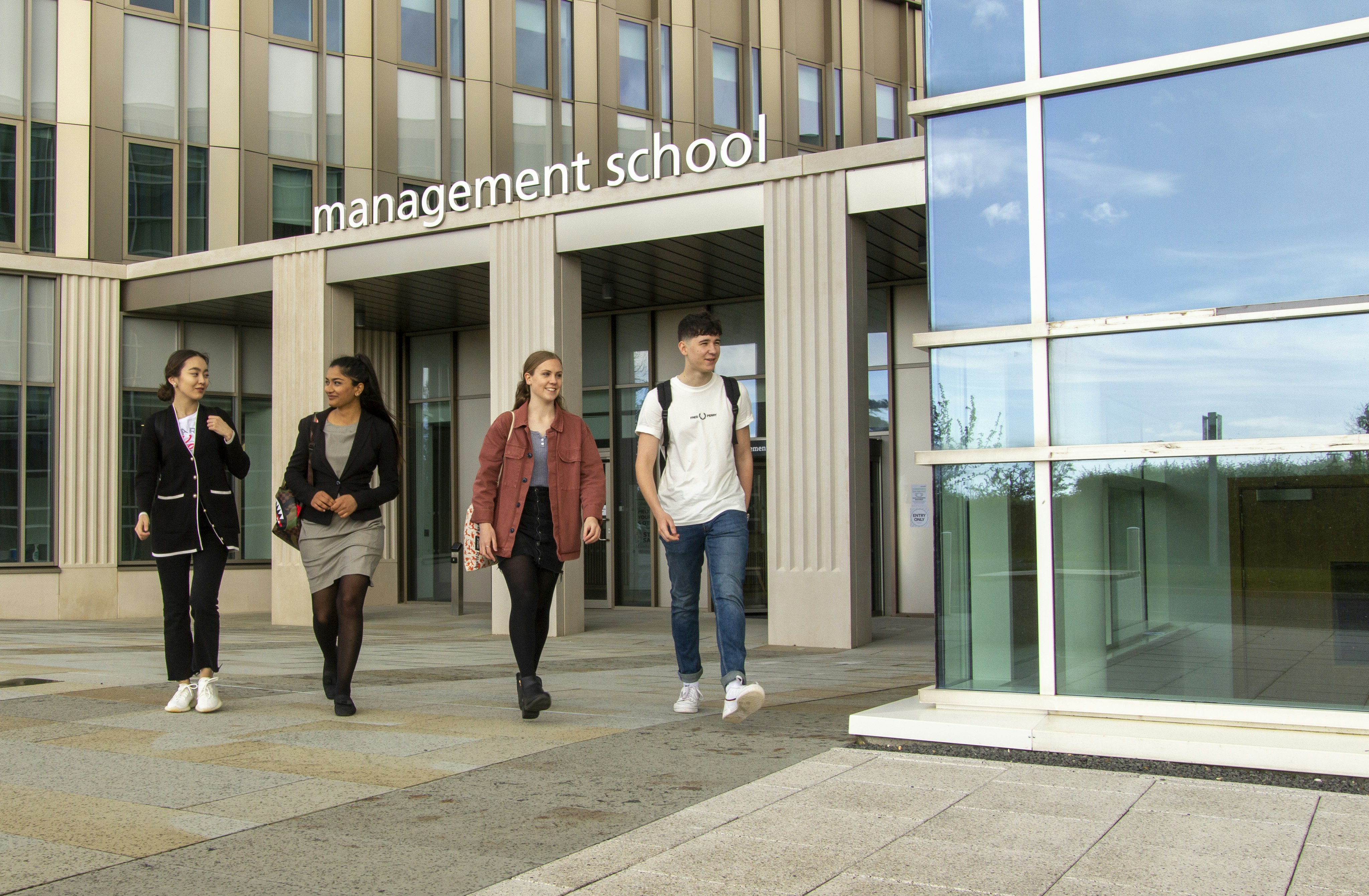 Students walking away from Lancaster University Management School's entrance