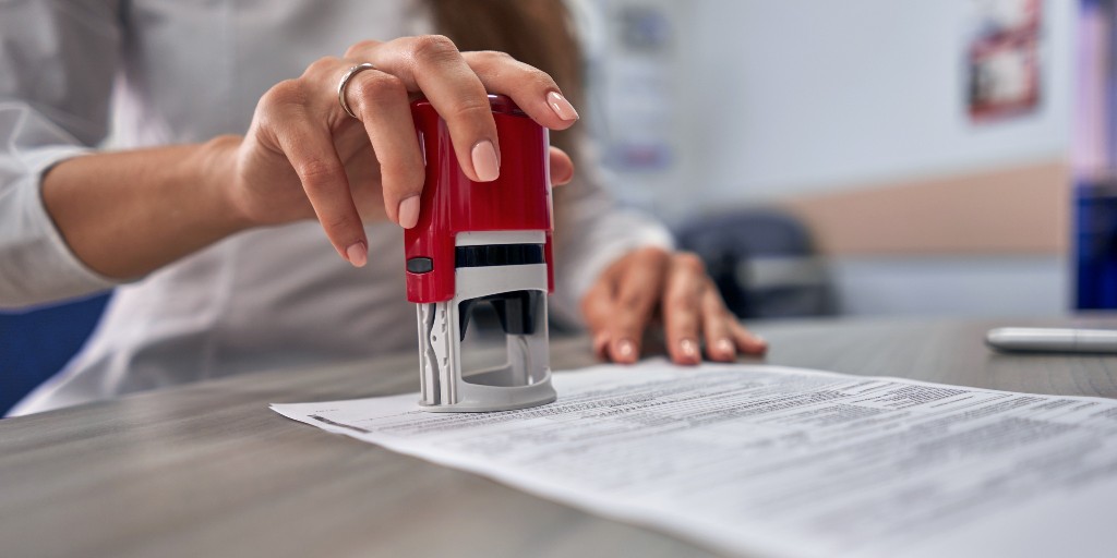 Woman stamping a document with black text on it