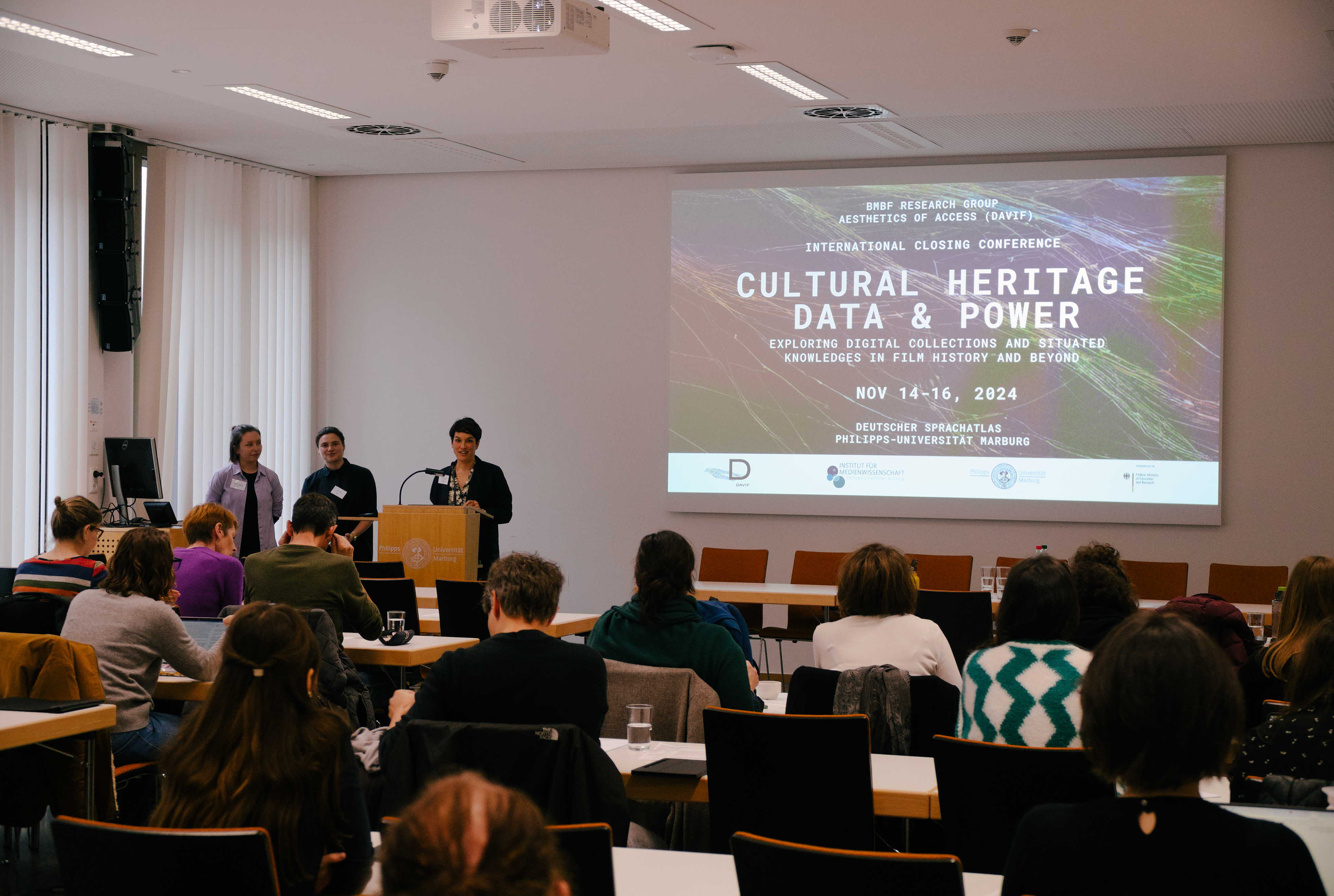 Pauline Junginger, Anne Hart & PI Sarah-Mai Dang opening the closing conference of the BMBF research group DAVIF "Cultural Heritage Data & Power" in front of a full room. 