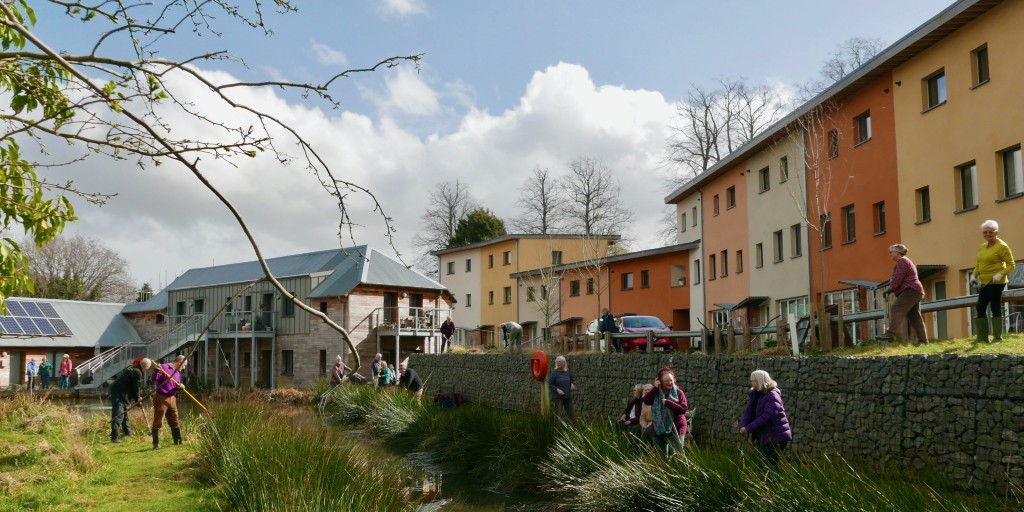 View of co-housing with people gardening
