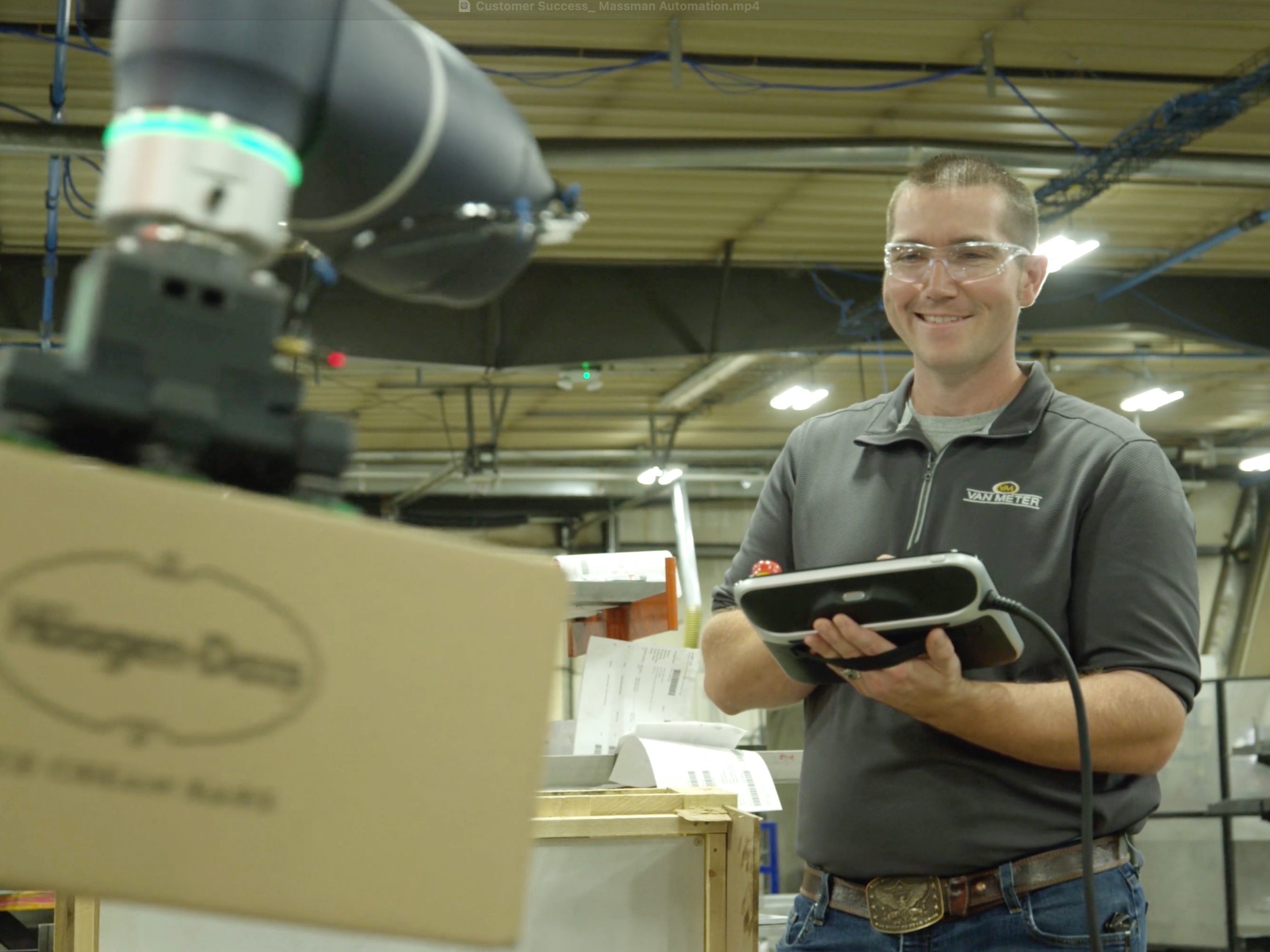 Cory Peterson controlling a collaborative robot as it picks up a box of ice cream.
