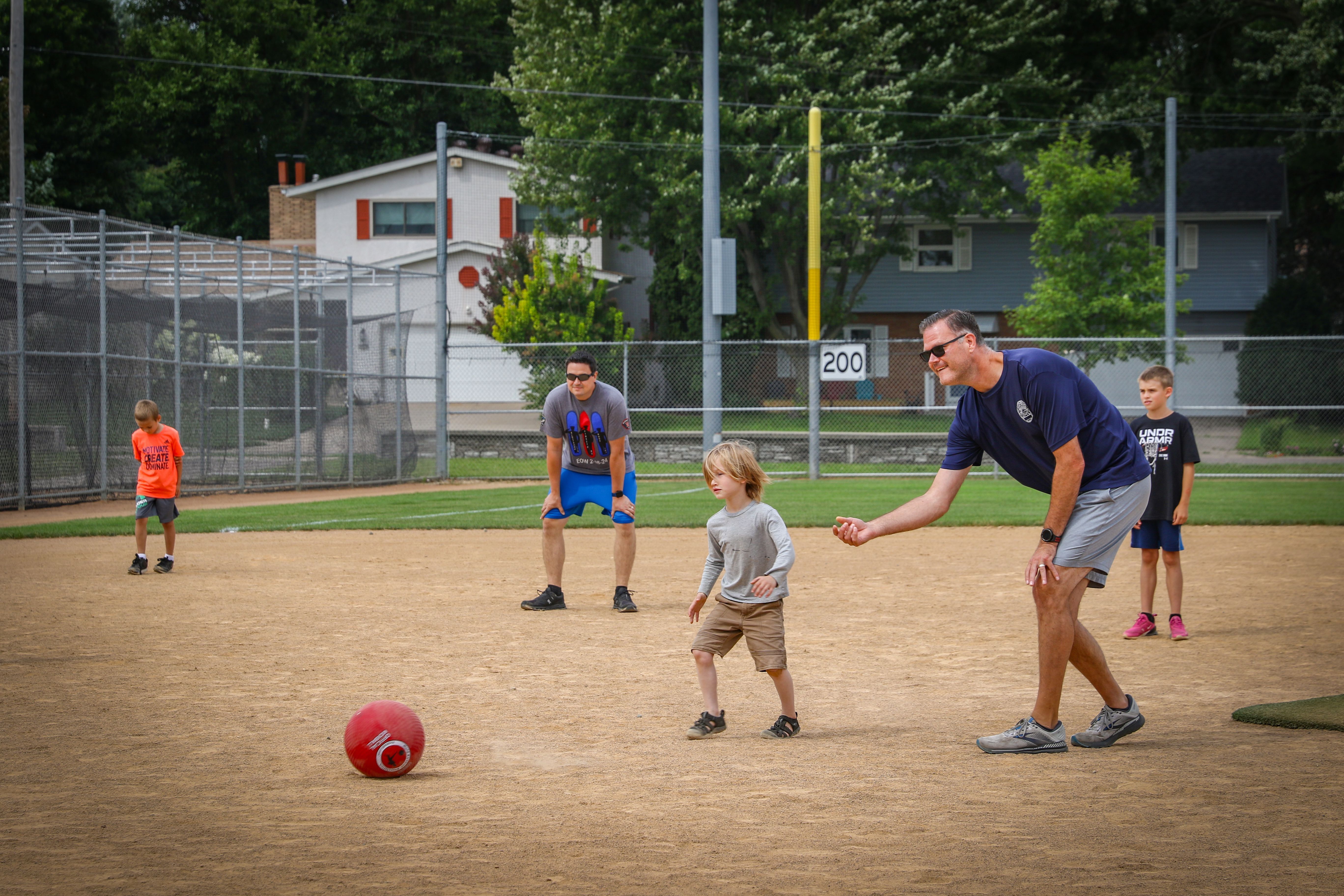 Police Officers playing kickball with a group of kids
