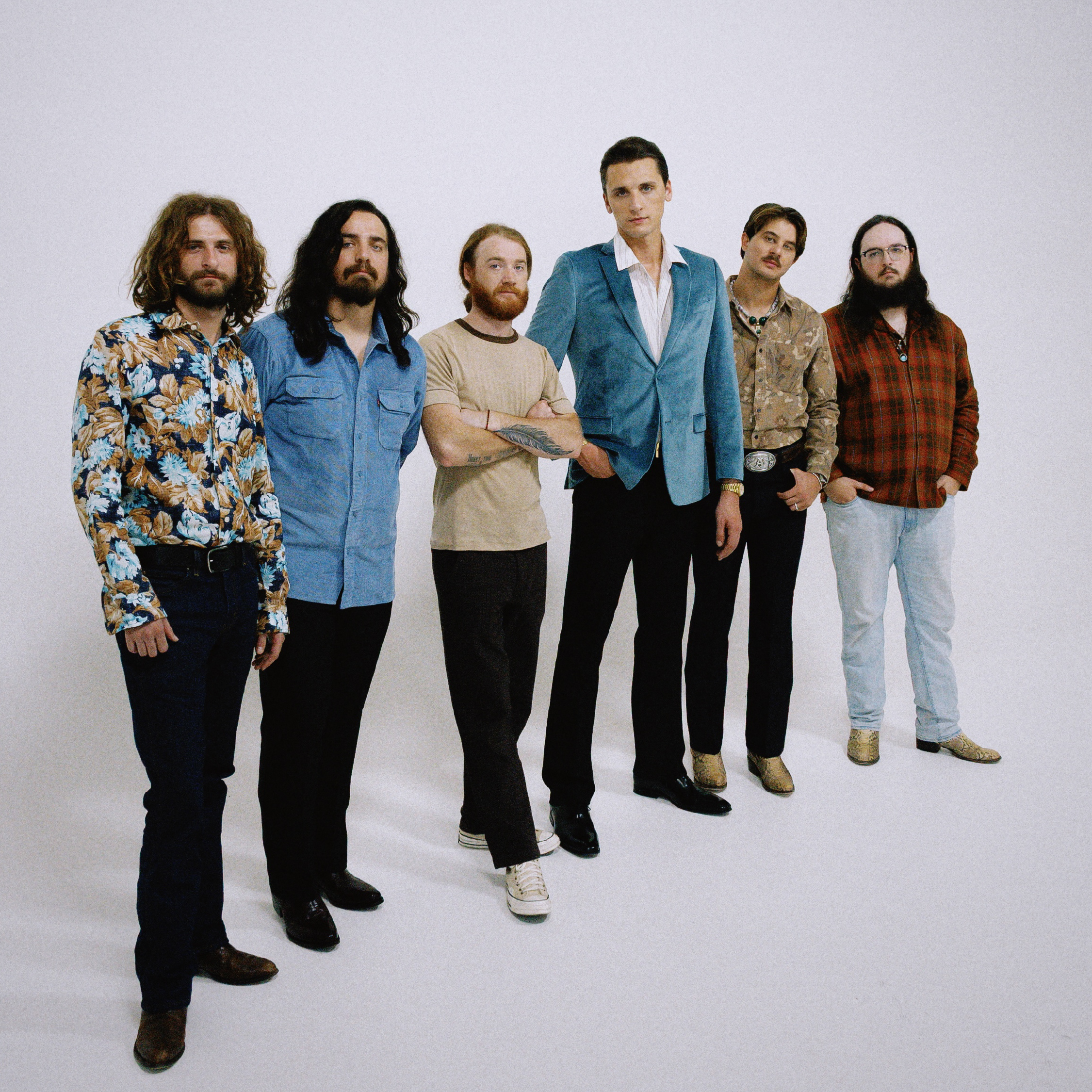 The members of the band The Red Clay Strays posting shoulder to shoulder with an entirely white background.