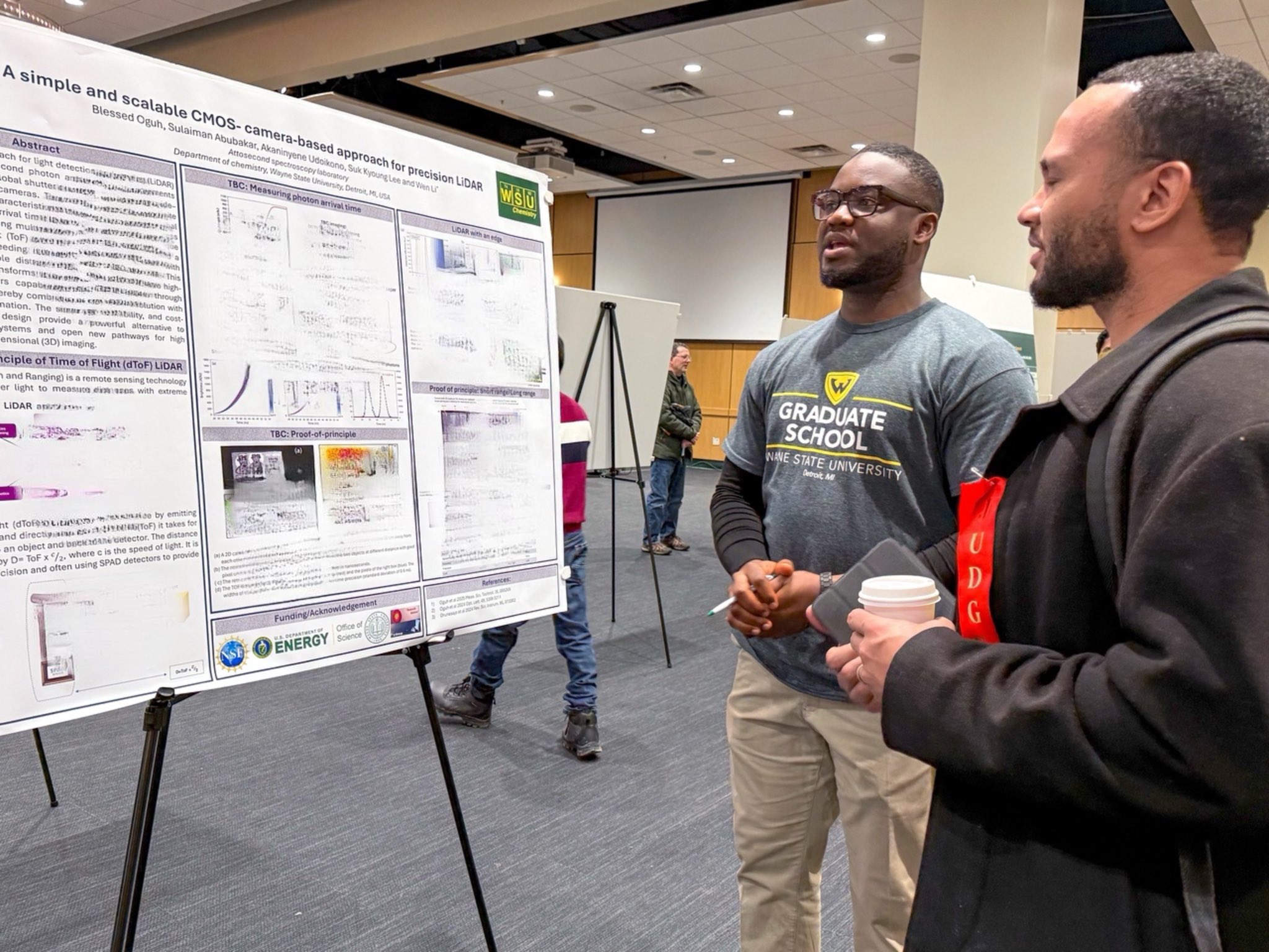 Graduate students discussing their research poster