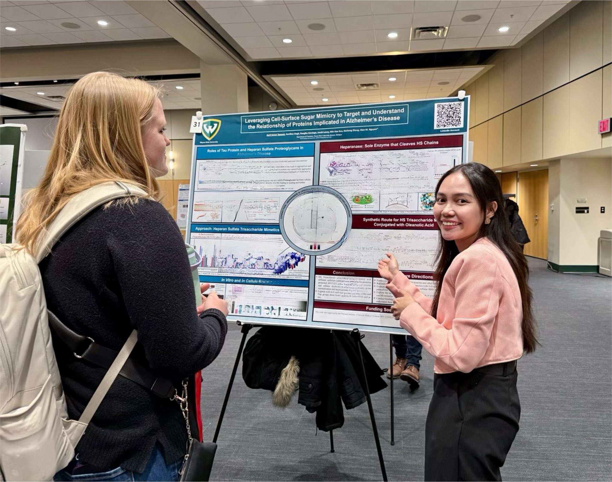 Graduate students discussing their research poster