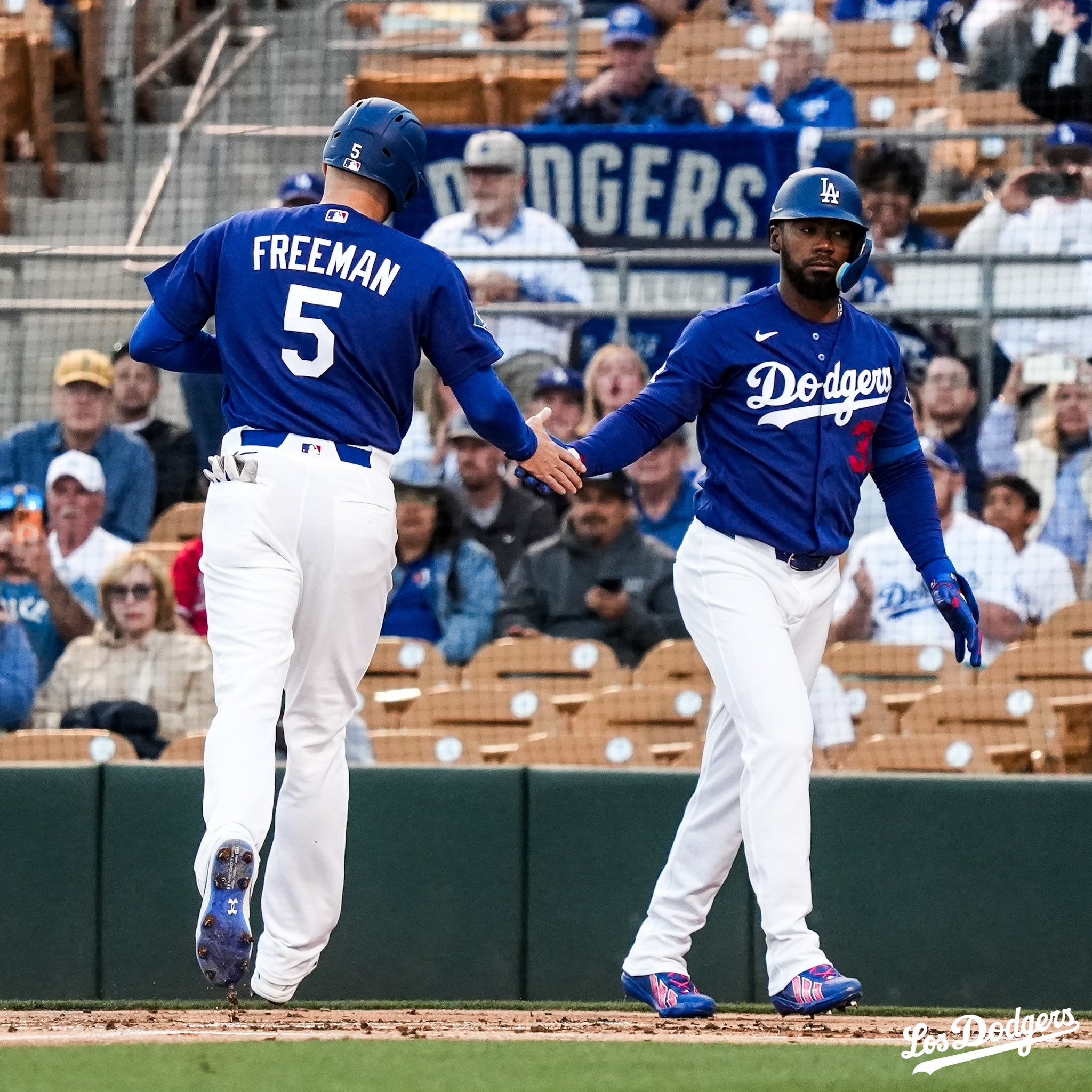 Freddie Freeman es recibido en el plato por Teoscar Hernández.