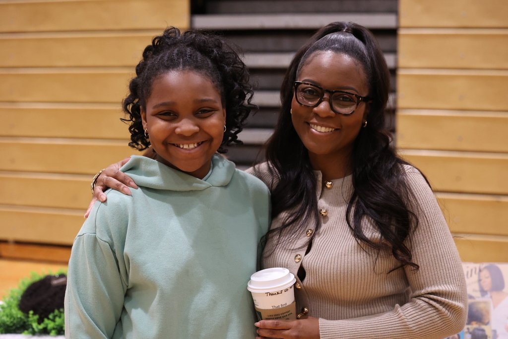 students and business rep pose for a photo holding a coffee career fair