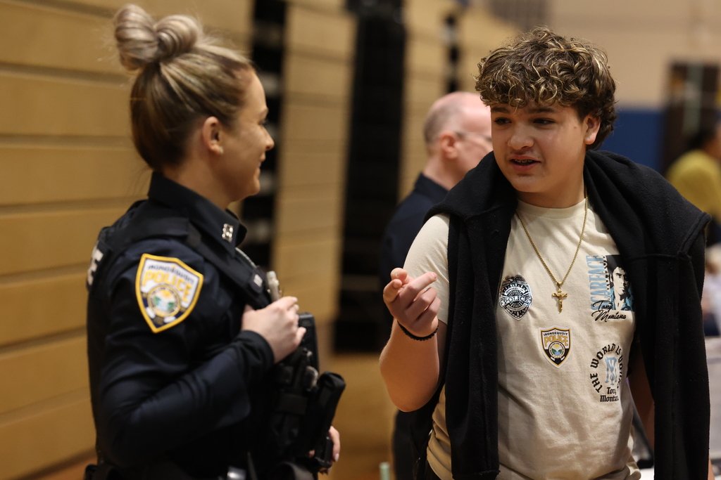 student talks to a police officer at Career Fair
