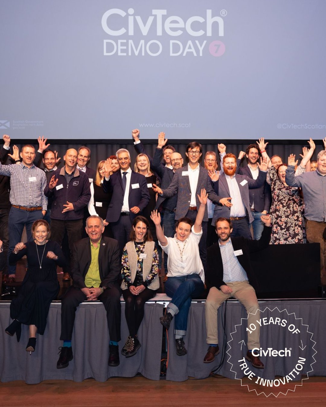 The CivTech Round 7 cohort posing on stage at Demo Day. A graphic overlay over the image reads "10 years of True Innovation"