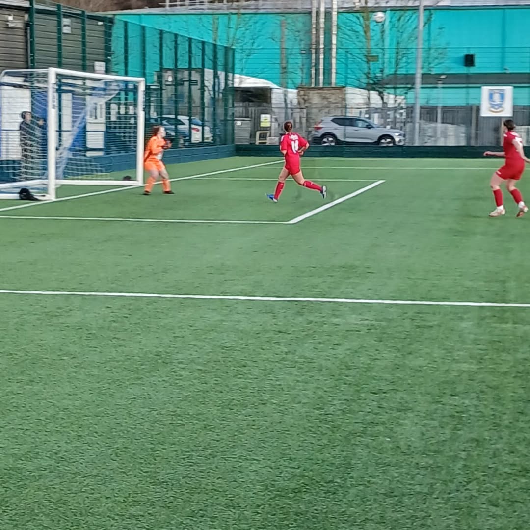 Milly Colford's free-kick floating in the penalty box.