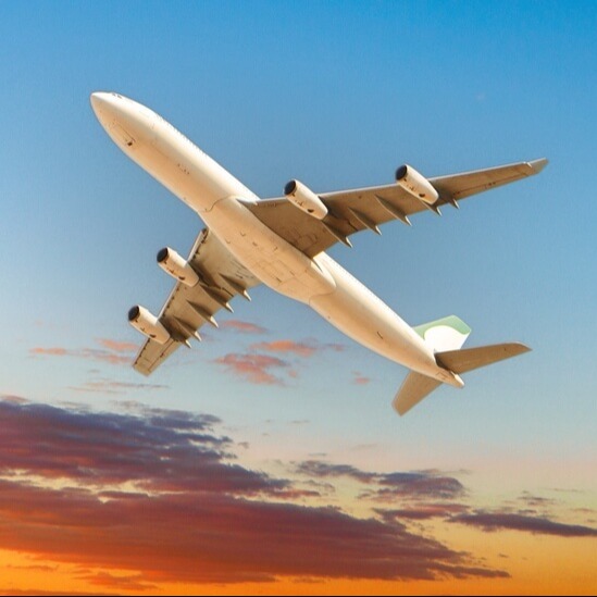 Plane flying over a sunset