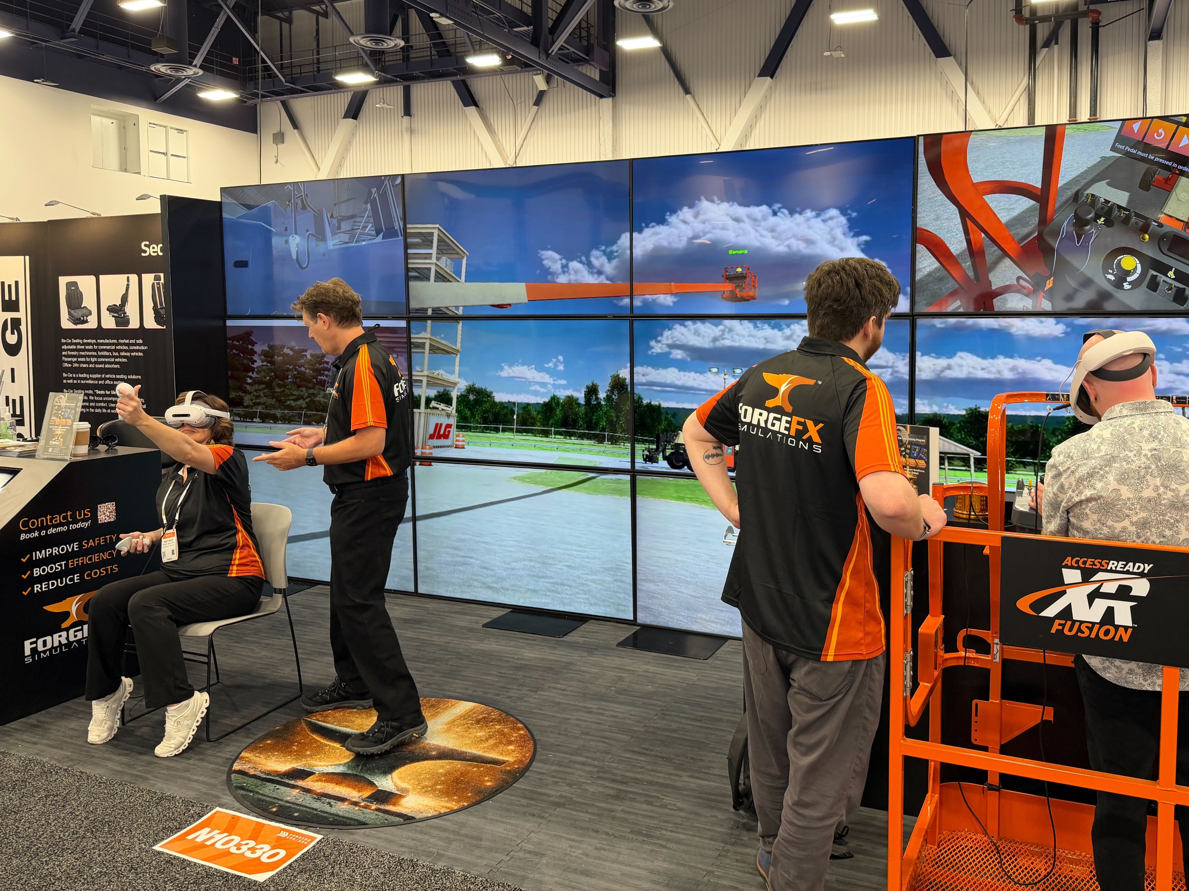 ForgeFX Simulations at CONEXPO-CON/AGG 2026: team members pose at the booth in front of a large video wall; CEO & Co-Founder Greg Meyers presents “From Iron to Impact” on the Ground Breakers Stage; attendees watch the session from white lounge seating; and visitors test immersive heavy equipment training demos using VR headsets and a bright orange lift simulator. Additional images show hands-on operator training, booth conversations, and live demonstrations of spatial computing-based training developed with partners including PICO XR. The photo set captures ForgeFX’s post-show highlights, customer engagement, and the company’s focus on safer, faster, and more measurable training for construction and industrial equipment operators.