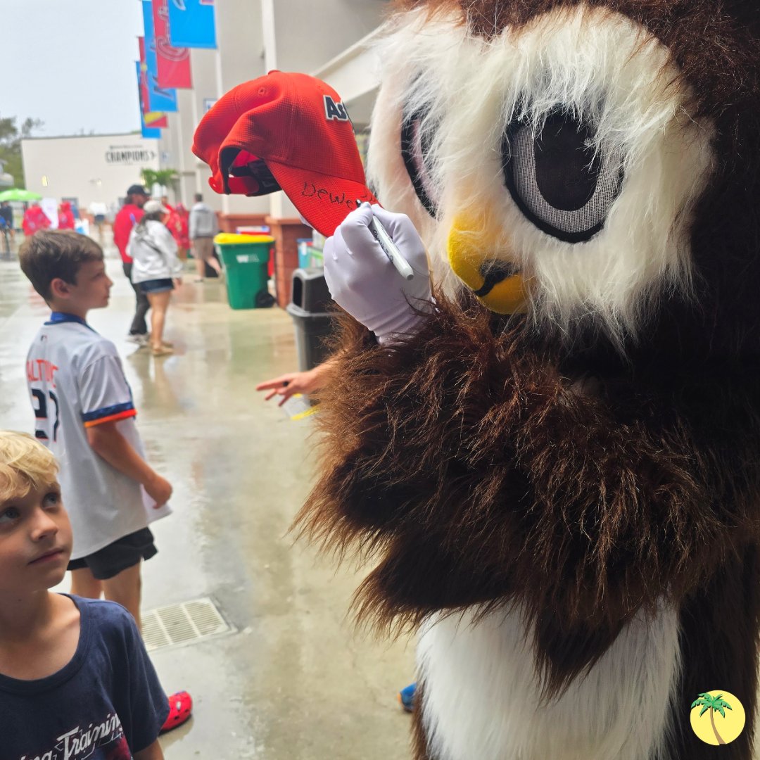 Dewey autographing a young fan's baseball cap.