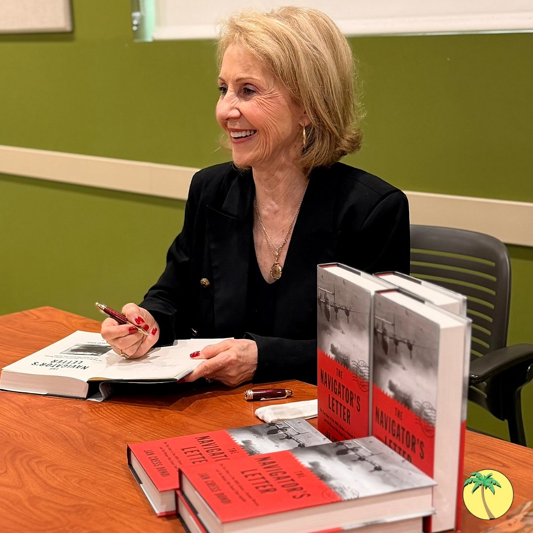 Jan smiling while signing her book.
