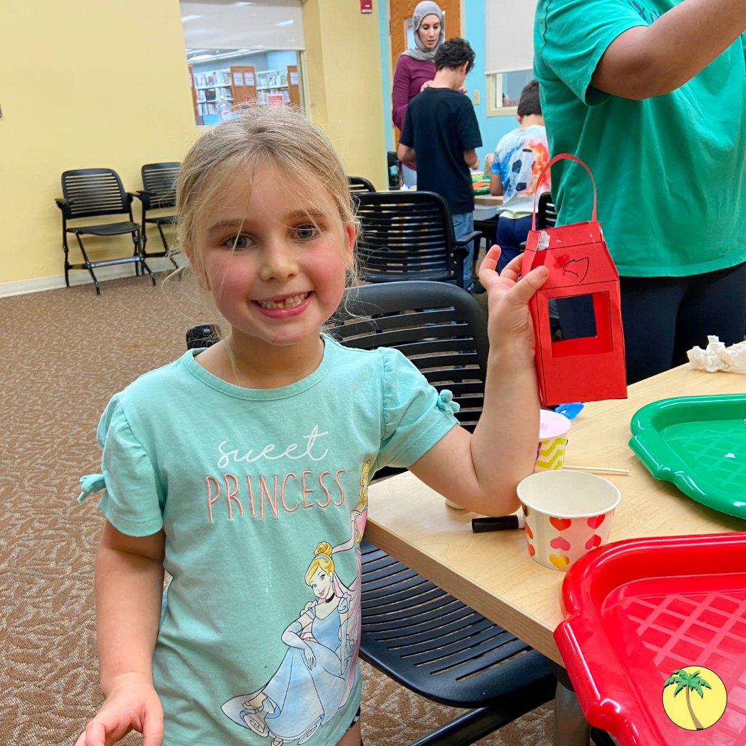 An elementary-aged girl holding a crafted lantern.