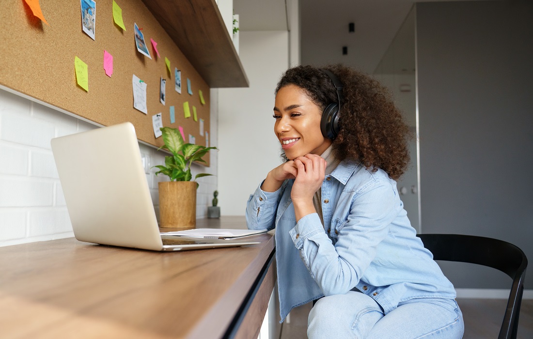 Young woman sat at a laptop.